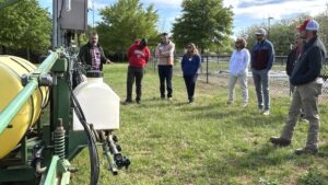 Extension agents looking at tractor
