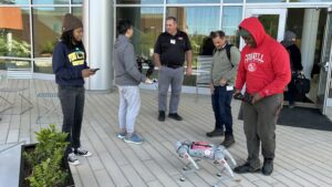 Extension agents looking at a robot
